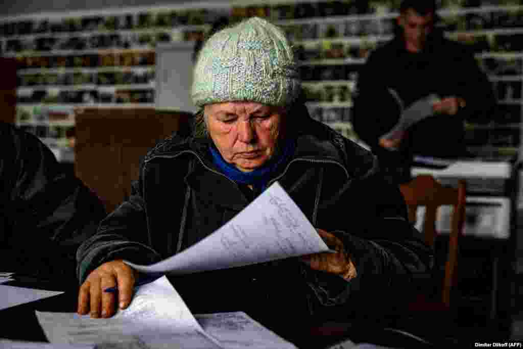 Anna Sukhova, 78, fills out paperwork for war crimes investigators before submitting her DNA to confirm the identity of her dead brother. &nbsp;