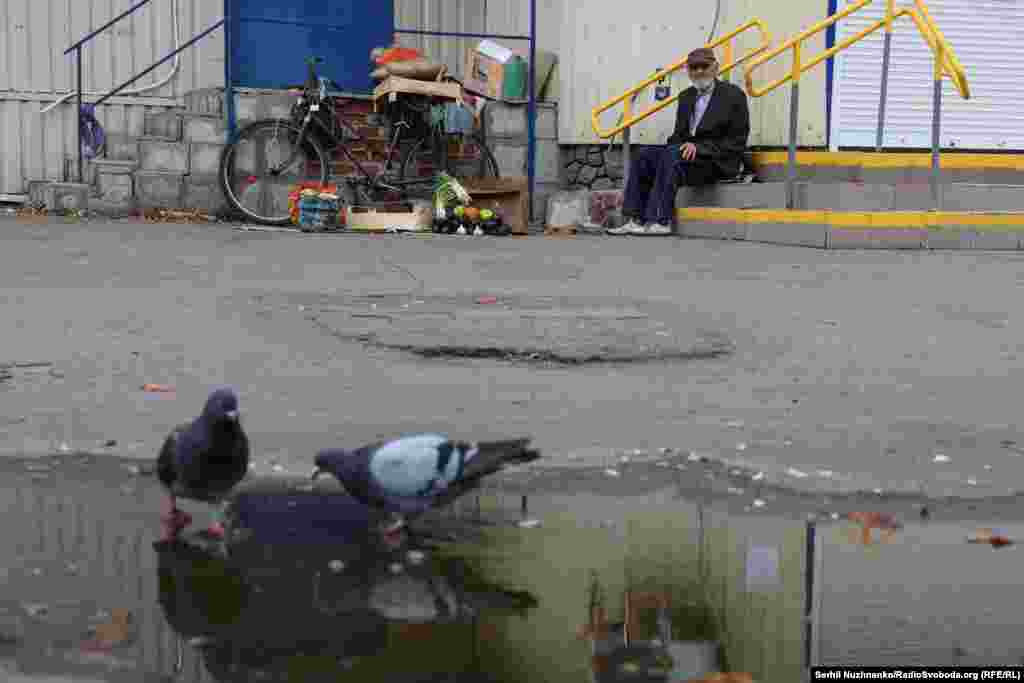 A man sells fruits and vegetables grown on his own plot of land near a closed supermarket in Pokrovsk.