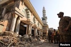 A Pakistani soldier and rescue workers survey the damage after a suicide blast in a mosque in Peshawar in January 2023.