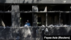 A man uses his mobile phone to take pictures inside the Radio Pakistan office building after it was set afire by supporters of Pakistan's former Prime Minister Imran Khan during a protest against his arrest in Peshawar on May 10.