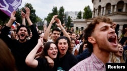 Supporters of the French left-wing alliance react to early results in the French parliamentary elections in Paris on July 7.