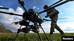 A Ukrainian soldier checks a connection with a Vampire attack drone before flying near the front line. The report says cooperation with China on network technology could provide Russia with the military breakthrough it desires.