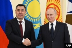 Russian President Vladimir Putin (right) shakes hands with Kyrgyz President Sadyr Japarov at a Eurasian Economic Union summit in St. Petersburg, Russia, on December 25, 2023.