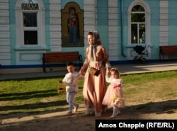 A woman brings her children to Easter Mass in Sarichioi.