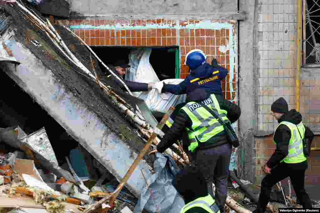 Rescuers remove the body of a Kyiv resident killed during the attack.