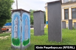 Stone sculptures from the collection of the historical museum in Dnipro stand enclosed in protective boxes.