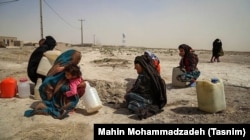 Women crouch in a former basin in Sistan and Baluchistan amid a severe water shortage on May 18.