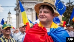 A young man wearing a Moldovan flag across his shoulders takes part in a pro-EU rally in Chisinau. (file photo)