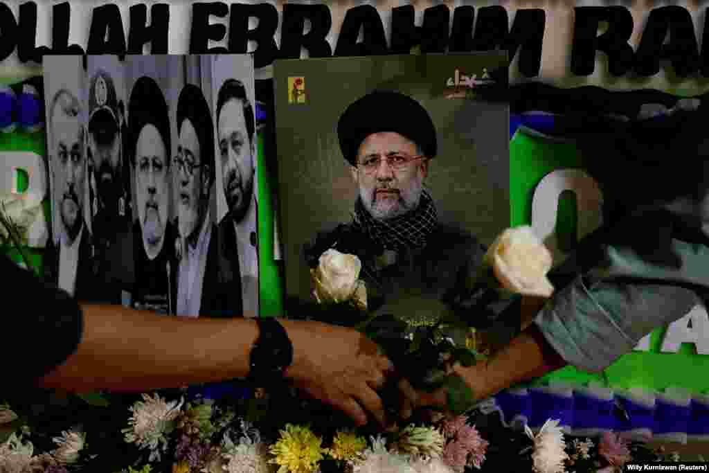 People lay flowers near pictures of Raisi during a vigil paying tribute to him and other victims outside the Iranian Embassy in Jakarta, Indonesia. European Council President Charles Michel said the European Union &quot;expresses its sincere condolences.&quot;