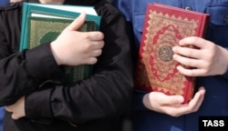 People holds copies of the Koran during a rally staged in Grozny on May 23.