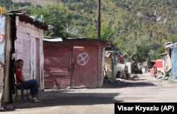 A resident sits in front of a makeshift cabin at Cesmin Lug in 2010.