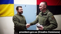 The military in the Kherson region presented President Volodymyr Zelenskiy (left) with a clock made from a damaged enemy cannon and featuring a map of Crimea on March 23.