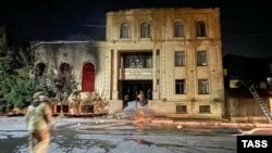 Emergency services personnel work at a local synagogue in Derbent set on fire early on June 24. 