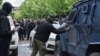 An masked man spray-paints the letter "Z" on to a security forces' vehicle during protests in Zvecan, northern Kosovo, on May 29. 