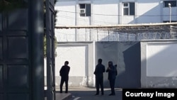 Muhsinjon Ahmedov (right) is escorted under police escort outside a detention facility in the city of Qoqon, Uzbekistan.