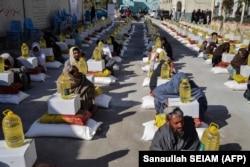 Afghan refugees deported from Pakistan receive food aid from the Red Cross Society in Kandahar on January 24.