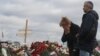 A woman weeps at an impromptu memorial to the victims of a shooting attack at a concert venue near Moscow. 