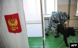 A police officer checks a polling station in Simferopol, Crimea, ahead of Russia's last presidential election on March 17, 2018.