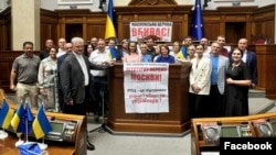 Lawmakers block the rostrum at Ukraine's Verkhovna Rada, urging parliament to continue considering a bill to ban the long Moscow-linked Ukrainian Orthodox Church on July 23.