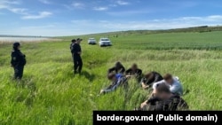 Moldovan border guards with Ukrainian men who entered the country illegally