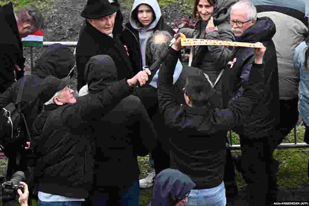 An elderly man (left) tries to block a demonstrator from protesting with a placard.