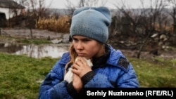 A 9-year-old girl named Sofiyka hugs her guinea pig during her evacuation from Makiyivka, in Ukraine's eastern Luhansk region, on November 19, 2022.