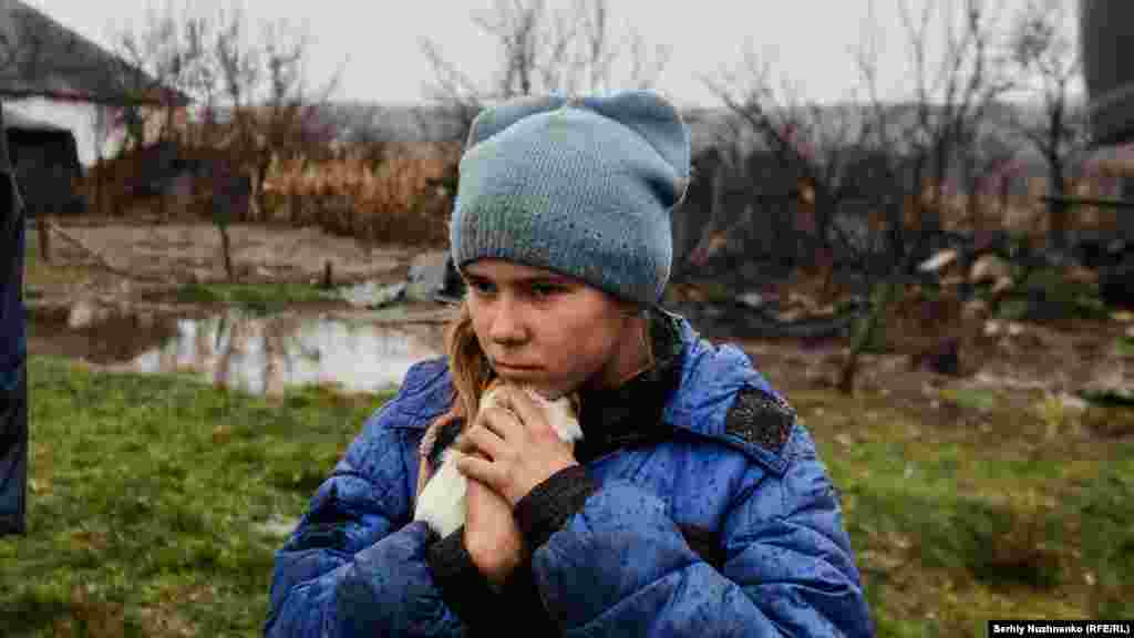 A 9-year-old girl named Sofiyka hugs her guinea pig during her evacuation from Makiyivka, in the eastern Luhansk region, on November 19, 2022.