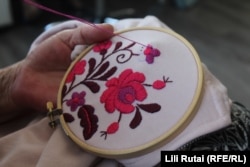 A MatyoDesign employee works on a piece of embroidery.