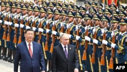 Russian President Vladimir Putin and Chinese leader Xi Jinping review a military honor guard during an official welcoming ceremony in Beijing in May. 