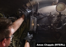 An engineer of a Tuzla Kriegslok checks the sight glass that indicates the level of water inside the boiler.