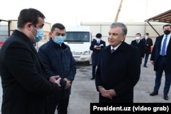 Khabibula Abdukadyr (second from left) visits a Tashkent City construction site with Uzbek President Shavkat Mirziyoev (third from left) in January 2022, as shown in a state TV program.