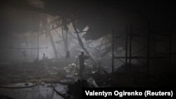 A firefighter works at the site where a printing plant was hit by a Russian strike on Kharkiv, Ukraine. 