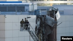 Investigators work near a damaged roof following a reported Ukrainian drone that was shot down in Moscow on August 18.