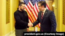 Ukrainian President Volodymyr Zelenskiy (left) shakes hands with the speaker of the U.S. House of Representatives, Mike Johnson, in Washington on December 12.