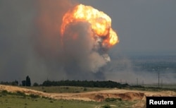 Smoke and flames rise from an explosion at a military training ground in the Kirovsky district of Russian-occupied Crimea on July 19.