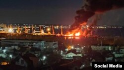 Smoke and flames fill the sky above the Crimean port of Feodosia on December 26, following a missile attack that hit a Russian landing ship.