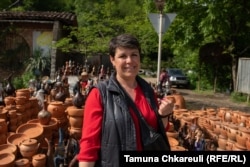 Zoya Giorgadze, who has sold ceramics by the roadside in Shrosha for decades, stands by her stall.