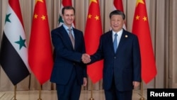 Chinese leader Xi Jinping shakes hands with ousted Syrian President Bashar al-Assad during a state visit to China in 2023. 