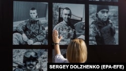 A woman attends a ceremony on Kyiv's Independence Square commemorating soldiers killed in a July 2022 strike that destroyed a building housing Ukrainian prisoners of war in Olenivka, eastern Ukraine. 