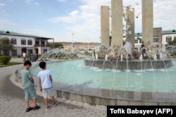 Children look at a fountain in the newly rebuilt village of Agali in the district of Zangilan on July 19, 2022.