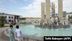 People stand around a fountain in July 2022 in the village of Agali, newly built by Azerbaijan in an area previously occupied by ethnic Armenian forces.