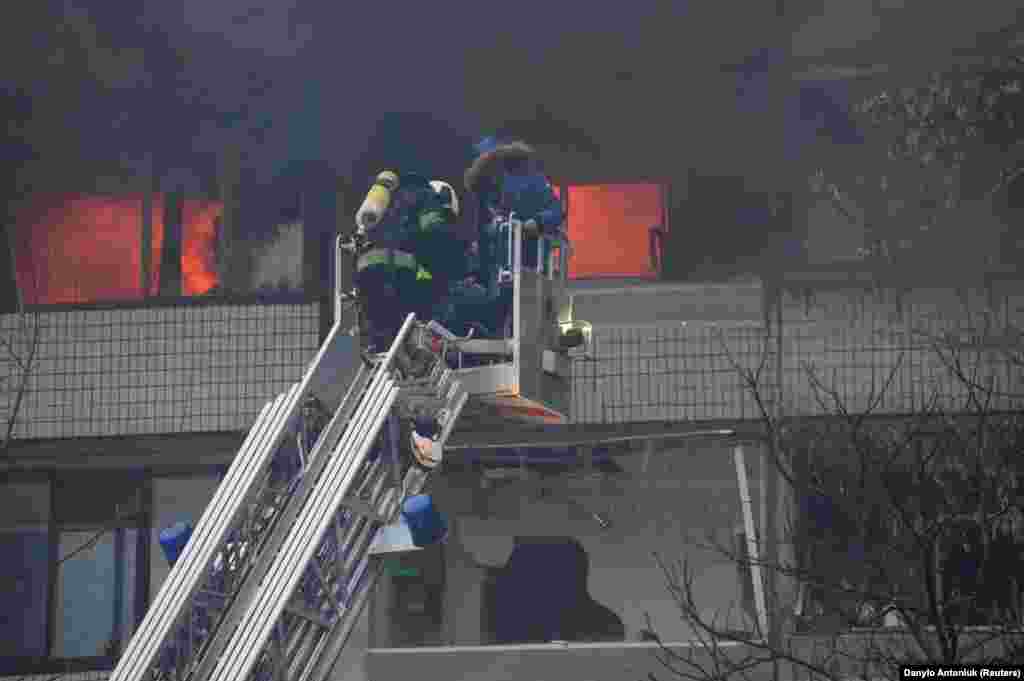 A firefighter evacuates a local resident from a burning residential building in Kyiv. Russia reportedly fired almost 100 missiles of various types, including Kinzhal hypersonic ballistic missiles. Zelenskiy said that at least 70 missiles were shot down, almost all of them in the Kyiv area. Western-supplied air defense systems such as Patriots and NASAMS had saved hundreds of lives, he added.