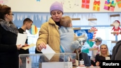 A woman casts her vote at a polling station in Belgrade on December 17.