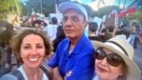 Parviz Sabeti stands between his wife and daughter during a rally in California against the Islamic republic in February 2023.