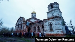 Parishioners mark Easter near a heavily damaged church in the village of Lukashivka, Chernihiv region, Ukraine, on April 16, 2023.