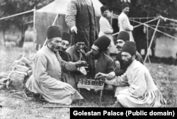 A “royal stablemaster” demonstrating a game of chess with other men.