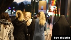 Several Iranian women are seen on a street in Tehran in April without the mandatory hijab.