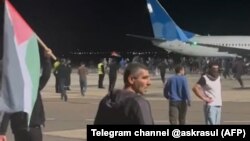 Protesters storm the runway of the airport in Makhachkala as a flight arrives from Israel late on October 29. 