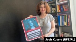 Investigative journalist Nino Zuriashvili with a photo of her face and the caption "There is no place in Georgia for agents."