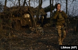 A female Ukrainian soldier looks on from her position on the front line in Bakhmut in March. Wearing military uniforms made for men is like a man wearing a bra -- “uncomfortable,” one Ukrainian female soldier said.